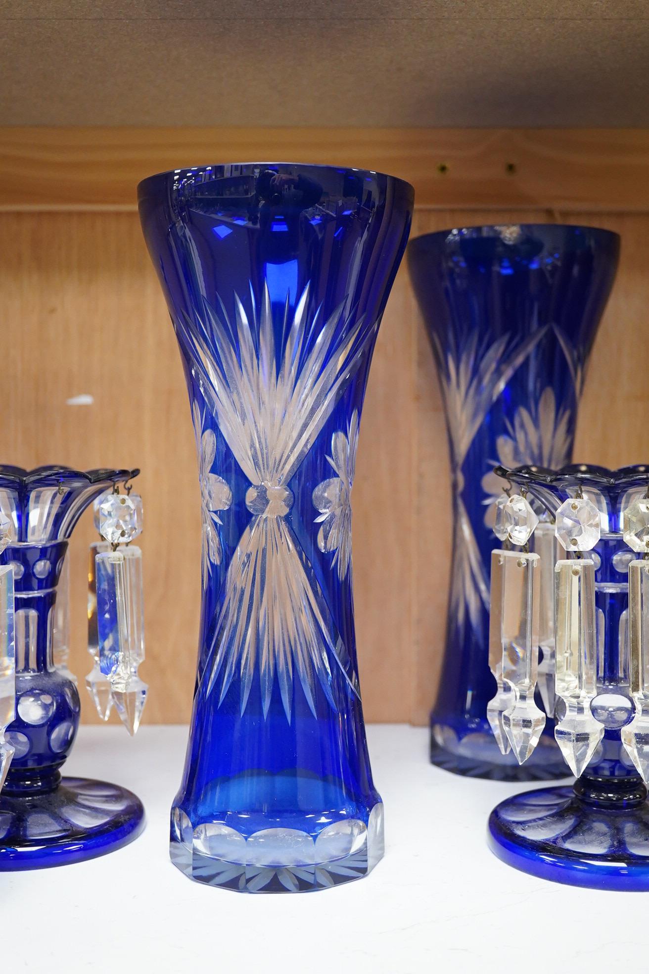 A pair of blue overlaid glass table lustres with drops and other blue overlaid glassware to include a pair of candlesticks and vases, largest 27cm high